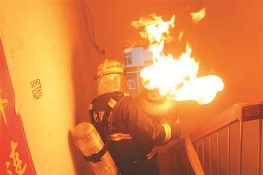 现场：煤气罐着火 消防员冒生命危险抱下7楼