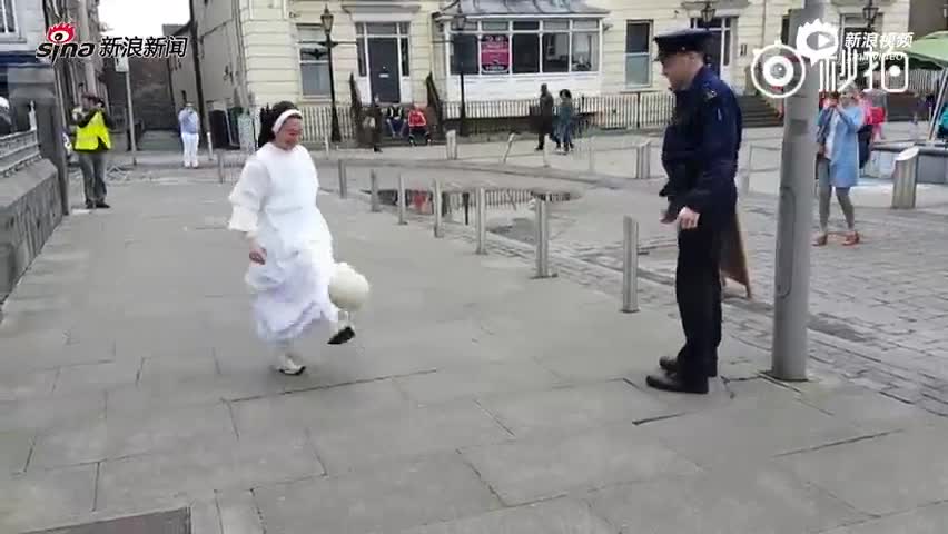 爱尔兰修女与警察街头踢球 路人驻足观看 