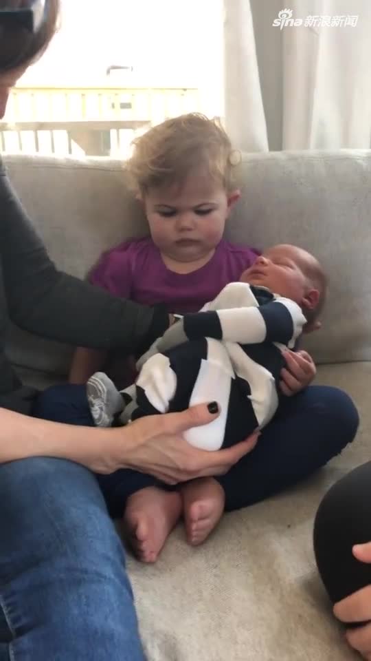 视频：反应过于真实！小女孩怀抱新生弟弟 眉头紧锁