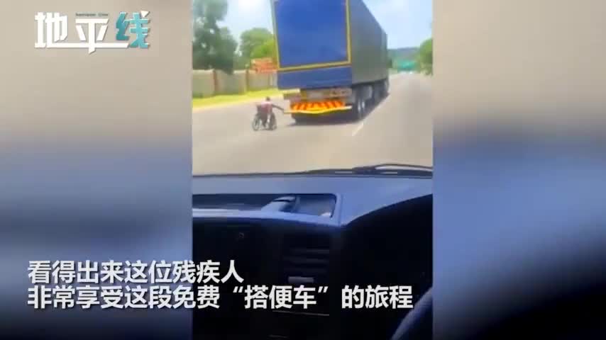 视频-轮椅男手攀货车尾部“搭便车” 在高速上时速