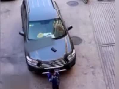安徽一小学生在轿车旁捡到钱包 趴引擎盖边写作业边等失主