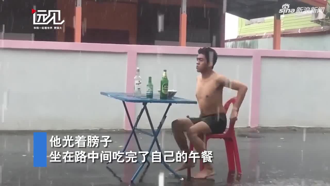 视频-泰国男子不顾狂风暴雨 悠闲自在地在雨中喝酒